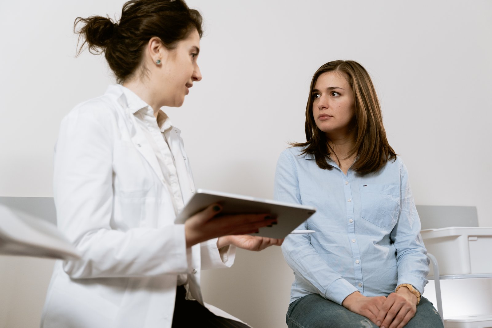 A woman sits at the gynecologist and talks to her