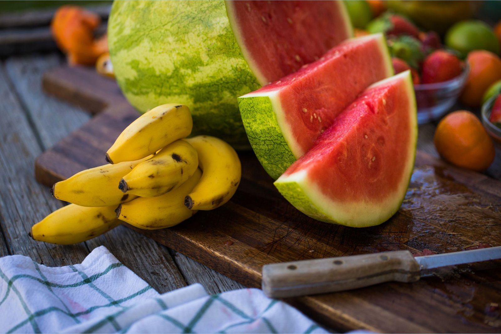 Potassium-rich bananas lie next to L-citrulline-rich sliced watermelon on a cutting board